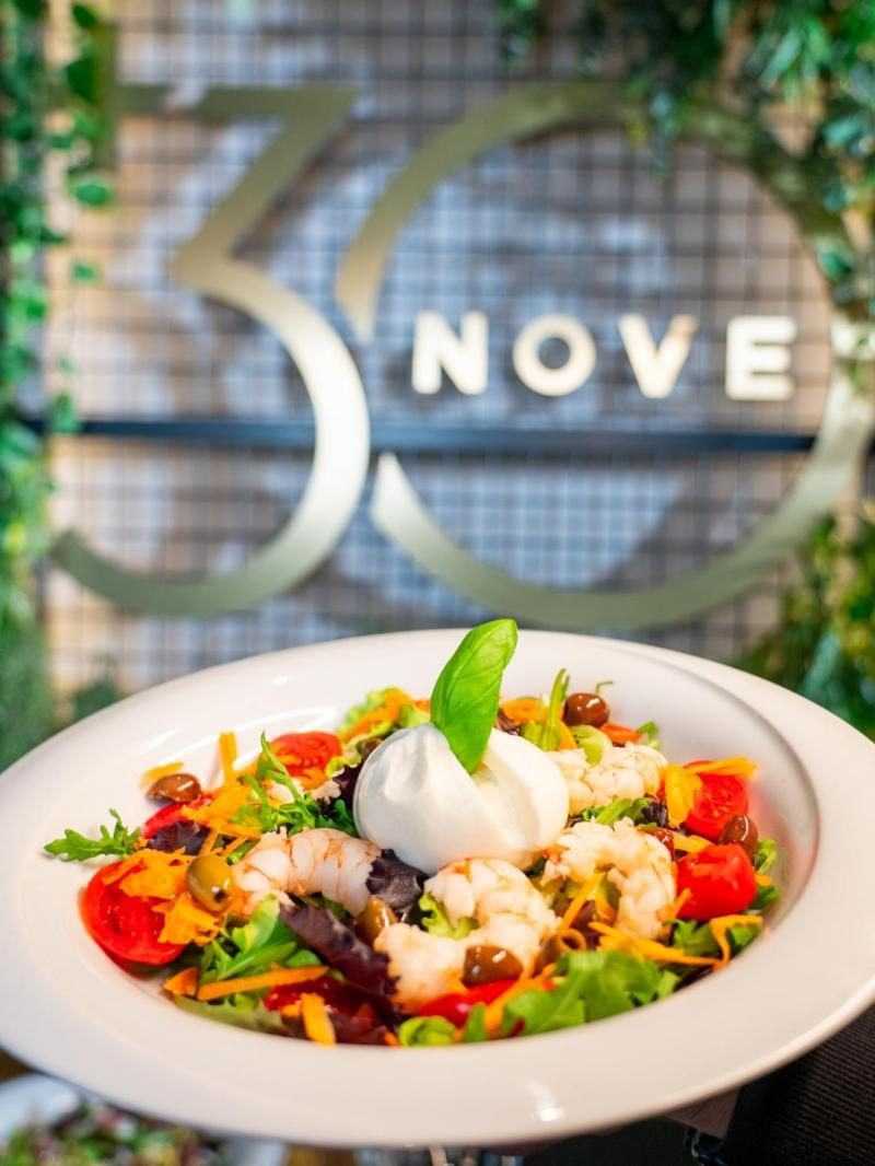 Insalata con burrata e gamberi davanti all'insegna del locale